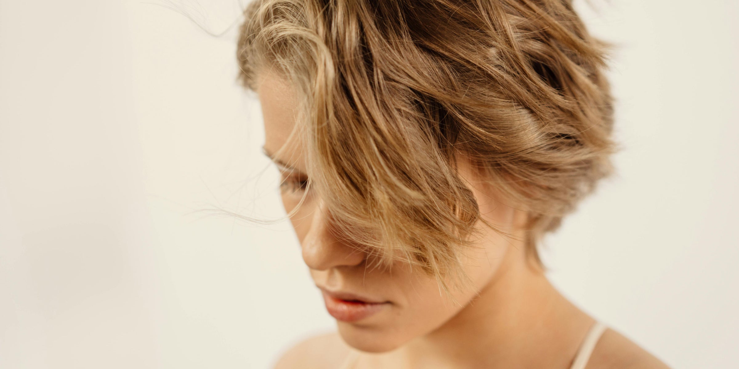Woman with short, wavy hair styled with soft texture and movement.