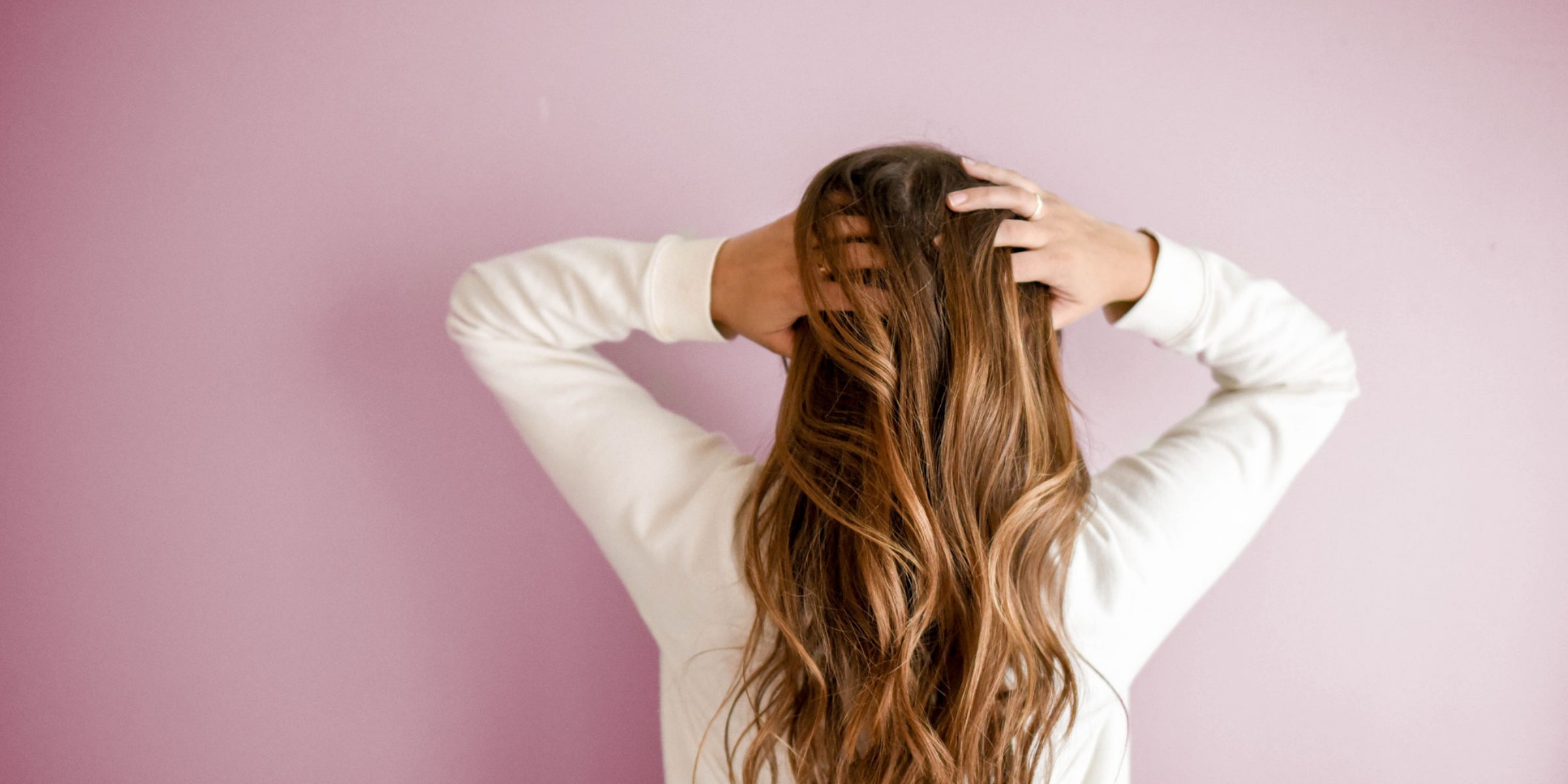 A person with long hair getting ready to air-style their hair.