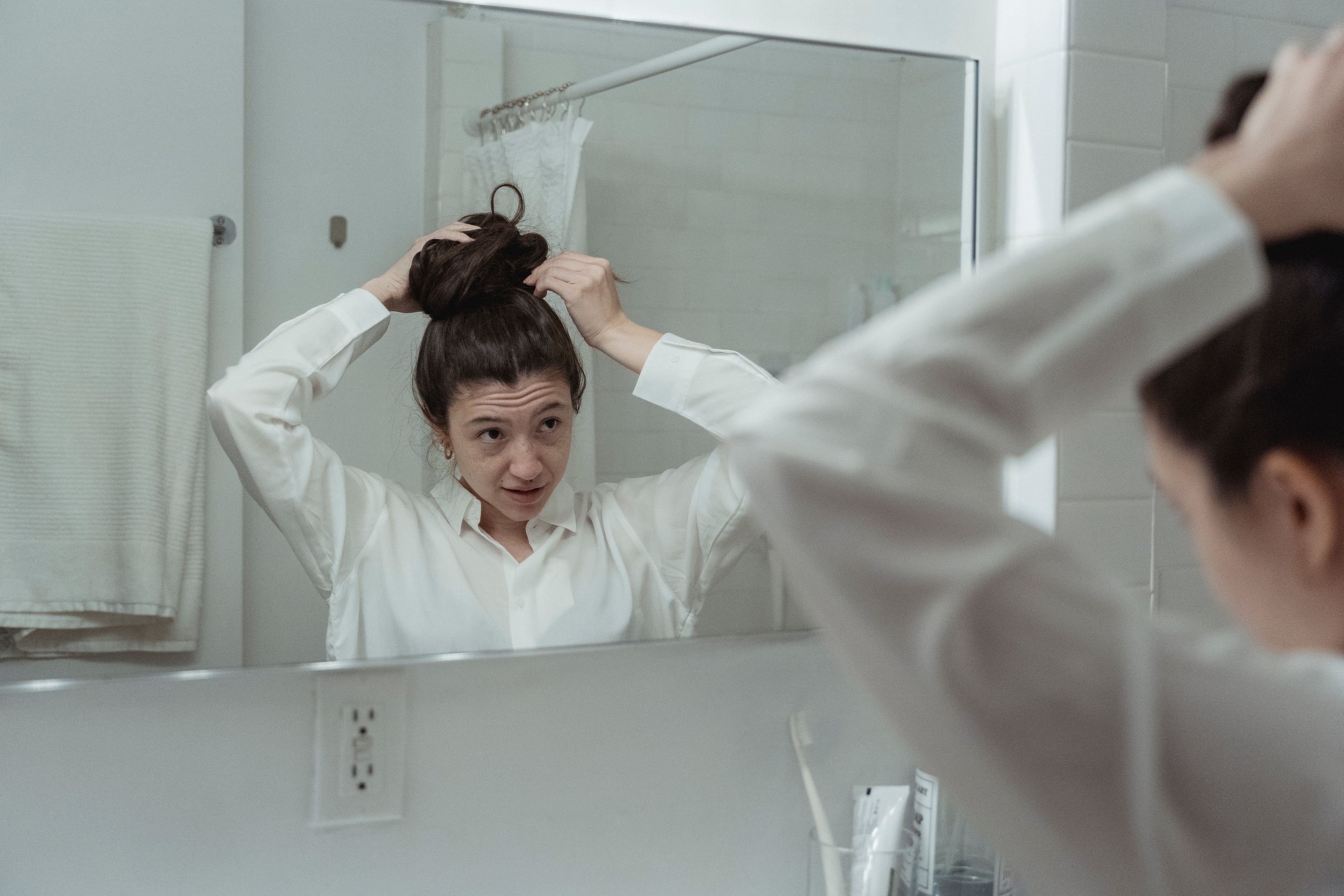 A woman styling her day-two hair.